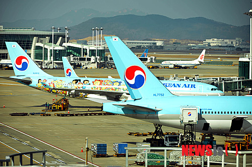 【인천공항=뉴시스】박문호 기자 = 이른바 '땅콩 회항' 사건의 조현아 전 대한항공 부사장에 대한 2차 공판이 열리는 30일 오후 인천국제공항공사 계류장 램프에 대한항공 항공기들이 승객을 기다리고 있다.&nbsp; 이날 서울서부지방법원에서 열린 공판의 증인으로 사건 피해자인 박창진 사무장과 여 승무원 김 모 씨, 조 전 부사장의 아버지인 조양호 대한항공 회장도 출석해 눈길을 끌고 있다. 2015.01.30.&nbsp; go2@newsis.com