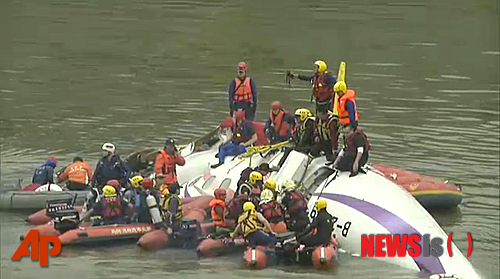 【타이베이=AP/뉴시스】58명이 탑승한 대만 트랜스아시아(푸싱·復興)항공사 여객기 한 대가 4일 이륙 직후 고가도로를 들이받고 하천에 추락해 최소 15명이 숨졌다고 현지 언론과 정부 관계자가 이같이 확인했다. 구조 관계자들이 현지 하천 지룽(基隆)천에서 추락한 사고기 동체인근에서 구조 작업을 진행하고 있는 모습. 2015.02.04