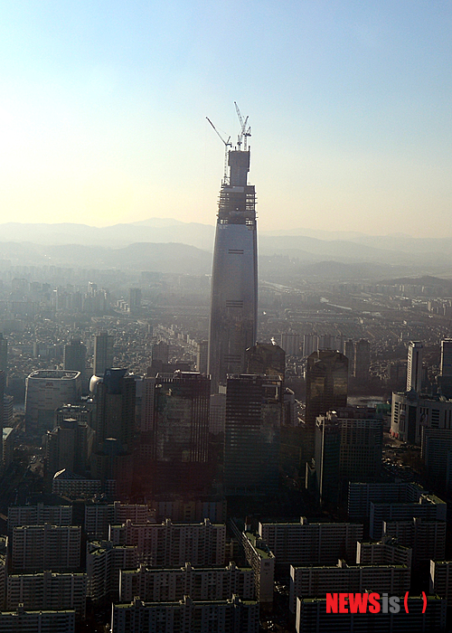 【서울=뉴시스】조성봉 기자 = 제2롯데월드 토목설계를 맡은 영국 에이럽사의 제임스 시즈 왕초 홍콩지사 부사장 등 초고층 전문가들이 12일 오전 서울 잠실 롯데월드 크리스탈볼롬에서 열린 시공기술 발표회에서 한목소리로 "제2롯데월드는 구조적으로 안전하다"고 밝혔다. 사진은 12일 오전 서울 상공에서 바라본 제2롯데월드 모습. 2015.02.12.&nbsp; suncho21@newsis.com