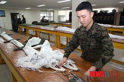 【서울=뉴시스】박주성 기자 = 낙하산을 이용해 공중으로 침투하는 특전용사에게 낙하산을 지원하는 육군특수전사령부 7공수특전여단 장비정비중대 김준태 상병이 낙하산을 포장하고 있다.&nbsp; 육군특수전사령부 7공수특전여단은 34년간 전술낙하산 9만개 무사고 지원을 달성했다. 2015.02.15. (사진=육군 7공수특전여단 제공)&nbsp; park7691@newsis.com 
