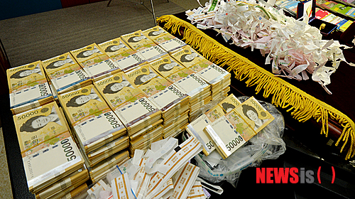 【광주=뉴시스】배동민 기자 = 광주지검은 16일 오전 5층 회의실에서 '한전 전산조작 입찰비리 사건'의 중간 수사 결과를 발표하고 입찰시스템 서버에 접속해 낙찰가를 알아내거나 조작하는 방법으로 특정 회사를 공사업체로 선정하고 돈을 받아온 전·현직 한전KDN 파견업체 직원 4명 등 6명을 구속기소했다고 밝혔다. 사진은 검찰이 피의자의 집에서 압수한 5만원권 현금과 통장 등의 모습. 2015.02.16.&nbsp; guggy@newsis.com