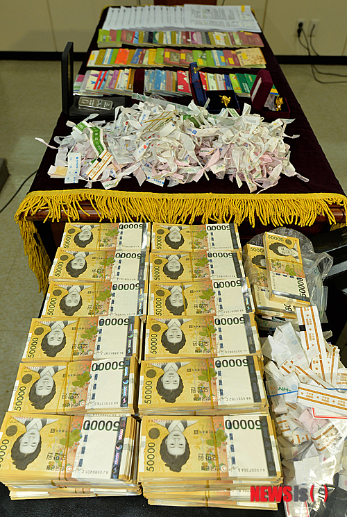 【광주=뉴시스】배동민 기자 = 광주지검은 16일 오전 5층 회의실에서 '한전 전산조작 입찰비리 사건'의 중간 수사 결과를 발표하고 입찰시스템 서버에 접속해 낙찰가를 알아내거나 조작하는 방법으로 특정 회사를 공사업체로 선정하고 돈을 받아온 전·현직 한전KDN 파견업체 직원 4명 등 6명을 구속기소했다고 밝혔다. 사진은 검찰이 피의자의 집에서 압수한 5만원권 현금과 통장 등의 모습. 2015.02.16.&nbsp; guggy@newsis.com