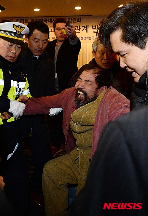 【서울=뉴시스】김진아 기자 = 우리마당 김기종 대표가 5일 오전 서울 종로구 세종문화회관 세종홀에서 열린 민족화해협력범국민협의회 주최 초청강연회에서 마크 리퍼트 주한미국대사를 습격해 연행되고 있다. 마크 리퍼트 대사는 이날 행사에서 한반도 평화와 통일, 그리고 한미관계 발전방향을 주제로 강연을 준비했다. 2015.03.05. bluesoda@newsis.com