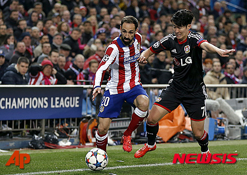Atletico's Diego Godin, left, and Leverkusen's Son Heung-min, right, challenge for the ball during the Champions League round of sixteen second leg soccer match between Atletico de Madrid and Bayer 04 Leverkusen at the Vicente Calderon stadium in Madrid, Spain, Tuesday, March 17, 2015. (AP Photo/Daniel Ochoa de Olza) 