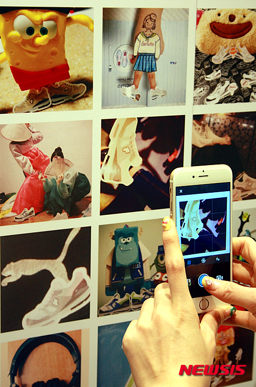 【서울=뉴시스】스포츠 브랜드 휠라(FILA)는 19일 서울 소공동 롯데백화점 본점 휠라 매장에서 최근 SNS 인스타그램 이벤트에 고객이 응모한 이미지들로 매장 기둥을 꾸민 ‘젤라티커 존’을 선보였다. 고객들이 젤라티커 존을 촬영하고 있다. 2015.03.19. (사진=휠라 제공) photo@newsis.com