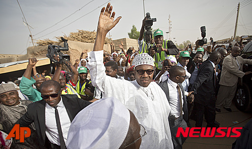 【다우라(나이지리아)=AP/뉴시스】지난달 28일(현지시간) 치러진 나이지리아 대선에서 장성 출신, 제1 야당 범진보의회당(APC) 무하마두 부하리(72) 후보가 굿럭 조너선(57) 현 대통령을 물리치고 승리했다. 승리를 확인한 부하리 후보가 31일 자신의 고향 다우라에서 지지자들을 향해 손을 흔드는 모습. 2015.04.01 