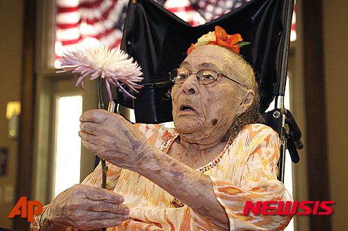 【캠던=AP/뉴시스】지난해 7월3일 촬영한 사진으로 미국 아칸소주 캠던의 요양원에서 거트루드 위버가 116세 생일을 하루 앞두고 꽃을 들고 있다. 116세의 위버 할머니가 세계 최고령의 타이틀을 얻은 지 5일 만에 별세했다. 2015.04.07