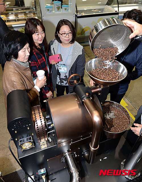 【서울=뉴시스】고범준 기자 = 9일 서울 강남구 코엑스에서 열린 2015 서울커피엑스포에서 시민들이 로스팅기계 시연 모습을 바라보고 있다. 2015.04.09.&nbsp; bjko@newsis.com