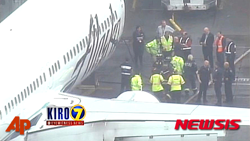 【시애틀=AP/뉴시스】미국 공항직원들이 13일(현지시간) 시애플에 있는 시애틀-타코마 국제공항에서 알래스카 항공 여객기의 화물칸에 갇혔던 멘지즈 항공 소속 화물 담당 직원을 데리고 나오고 있다. 시애틀에서 로스앤젤레스로 향하던 알래스카항공 소속 여객기는 이날 이 직원이 깜박 잠든 새 화물칸에 갇혀 시애틀로 회항했다. 2015.04.14