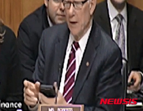 【서울=뉴시스】팻 로버츠(78) 미국 공화당 상원의원이 국회의사당에서 열린 미 관세정책과 관련한 상원 금융위원회 청문회 도중 자신의 휴대폰 벨소리가 울리자 황급히 끄고 있다. 그는 이날 청문회 중 의도치 않게 디즈니 애니메이션 주제곡 벨소리에 팽팽한 긴장감을 깨뜨렸다고 CNN이 보도했다. (사진 출처: CNN인터넷판) 2015.04.18