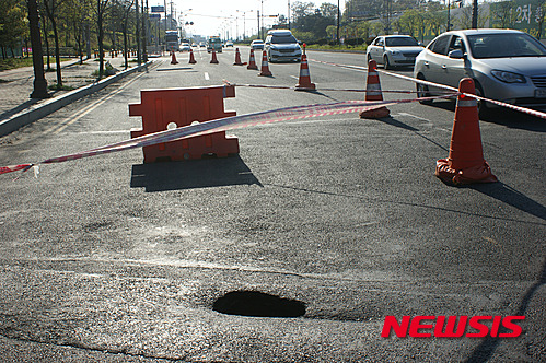 【천안=뉴시스】이종익 기자 = 지난해 7월 2m×2m 원형 크기로 깊이를 알 수 없는 씽크홀(지반침하)이 발생한 충남 천안시 서북구 삼성대로 IC방향의 영성지하도 인근에서 25일 오후 또 다시 약 1m×0.5m 타원 크기로 도로가 함몰되는 씽크홀이 발생했다. 2015.04.26.&nbsp; 007news@newsis.com