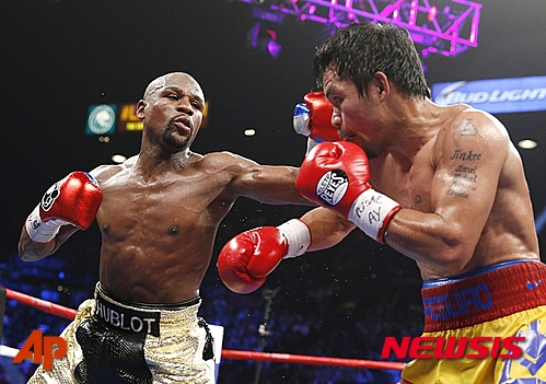 【라스베이거스=AP/뉴시스】플로이드 메이웨더 주니어(38·미국·왼쪽)가 3일(한국시간) 미국 네바다주 라스베이거스의 MGM 그랜드 가든 아레나에서 열린 매니 파퀴아오(37·필리핀)와의 세계복싱협회(WBA), 세계권투평의회(WBC), 세계복싱기구(WBO) 웰터급 통합 타이틀전에서 주먹을 날리고 있다.2015.5.3.