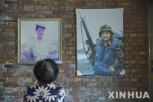 [대만=신화/뉴시스] 한 관광객이 대만의 가오슝에 위치한 덩리쥔(등려군) 박물관을 찾아 벽에 걸린 덩리쥔의 사진을 보고있다. 2015.05.07.