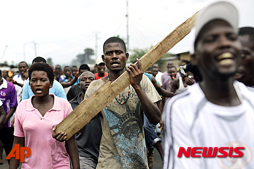 【무사가(부룬디)=AP/뉴시스】브룬디 시위대가 18일(현지시간) 수도 부줌부라 인근 무사가에서 가두행진을 하고 있다. 이날 무사가에서 열린 피에르 은쿠룬지자 대통령 3선 출마에 항의하는 시위 진압에 군이 투입됐다. 2015.05.19