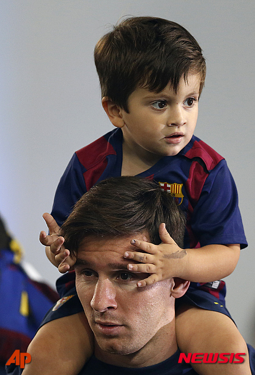 Barcelona's Lionel Messi carries his son on his shoulders after celebrations at the Camp Nou stadium in Barcelona, Spain Sunday June 7, 2015 after winning the Champions League final soccer match Saturday by beating Juventus Turin 3-1. Barcelona won the triple this season winning the Spanish League title, the Copa del Rey and the Champions League. (AP Photo/Manu Fernandez) 
