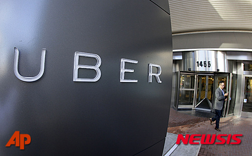 【샌프란시스코=AP/뉴시스】2014년 12월16일 자료사진으로 미국 남성이 샌프란시스코에 있는 우버 본사를 나가고 있다. 모바일 앱으로 차량과 승객을 연결해주는 택시 서비스 우버를 통해 승객을 태우는 운전자는 개인사업자가 아닌, 이 회사의 피고용인으로 봐야 한다는 미국 캘리포니아주(州) 노동위원회의 결정이 16일(현지시간) 공개되면서 우버 서비스뿐 아니라 우버처럼 수요 대응 서비스를 제공하기 위해 고용인을 개인사업자로 보는 회사들까지 광범위한 파장을 불러일으킬 것으로 보인다. 2015.06.18
