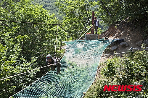 【화천=뉴시스】박혜미 기자 = 육군 27사단 수색대대는 지난 15일부터 19일까지 군단 쌍용유격장에서 수색대대 장병 300여명이 참가한 가운데 분대(팀)단위 유격전수행능력을 갖추고 기초·산악장애물 극복능력과 생존술을 숙달하기 위한 전문유격훈련을 실시하고 있다. 사진은 수색대대 장병이 전문유격 훈련 간 줄 하나에 의지해 이동 제한지역을 극복하는 외줄타기 훈련을 하고 있는 모습. 2015.06.19. (사진=육군27사단 제공)&nbsp; photo@newsis.com