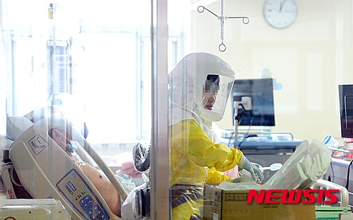 【서울=뉴시스】박영태 기자 = 19일 오전 서울 중구 국립중앙의료원 음압시설이 갖춰진 중환자실에서 의료진이 메르스 환자를 돌보고 있다. 2015.06.19. photo@newsis.com