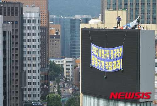 【서울=뉴시스】임태훈 기자 = 기아자동차 화성공장 비정규직 노동자 최정명(45)씨와 한규협(41)씨가 29일 오후 서울 중구 국가인권위원회 옥상 전광판에서 기아자동차 비정규직 노동자의 정규직 전환을 요구하며, 19일째 고공농성을 하고 있다. 2015.06.29. taehoonlim@newsis.com