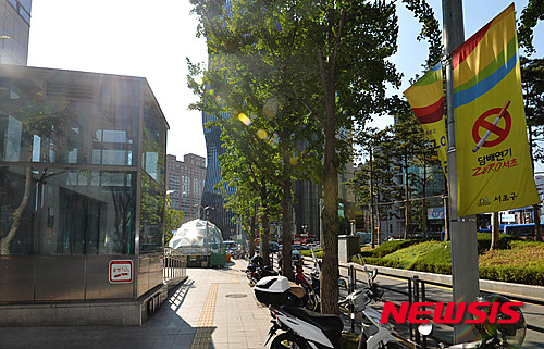 【서울=뉴시스】박문호 기자 = 1일부터 서울 서초구 지하철 출입구 주변 10m 이내가 모두 금연구역으로 지정돼 서초구는 구내 지하철역 22곳의 121개 출입구 주변에서 흡연자 집중 단속에 나선다.  사진은 이날 오후 서울 서초구 강남역 지하철역 출입구 주변에 금연을 알리는 깃발과 대형 스티커가 붙어 있는 모습. 2015.07.01.  go2@newsis.com