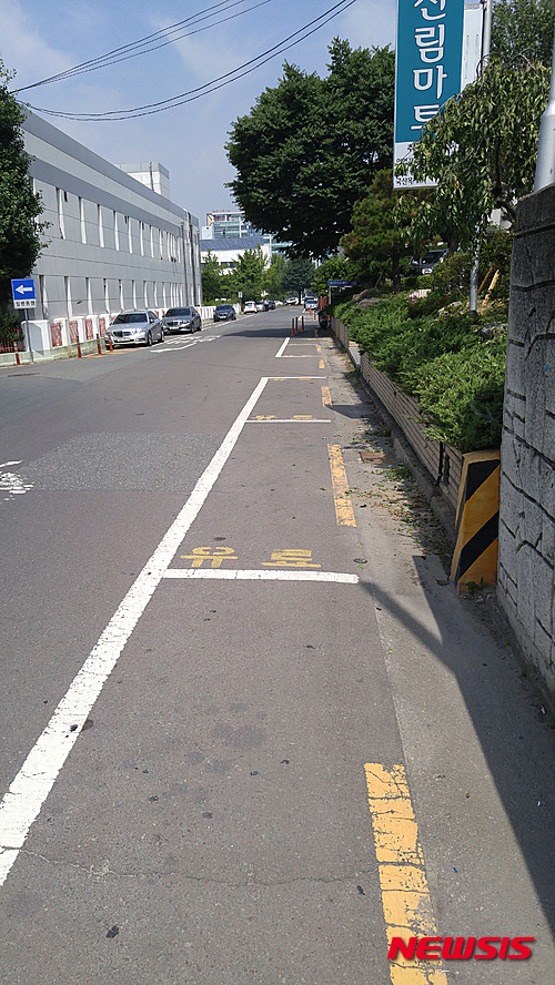 【창원=뉴시스】강승우 기자 = 경남 창원시 의창구 신월동의 일부 유료 노상주차장(사진)이 주차장법 시행규칙에 맞지 않는 규격으로 구획이 설정된 사실이 3일 뉴시스 취재결과 확인됐다. 주차장법 시행규칙에 따르면 노상주차장 주차 구획은 너비가 2m 이상이어야 한다고 규정하고 있지만 해당 노상주차장의 주차 구획 너비는 1.7m~1.8m로 시행규칙에 미치지 못했다. 2015.07.03.    ksw@newsis.com 