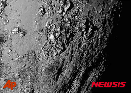 【케이프커내버럴(미국)=AP/뉴시스】14일 미국 항공우주국(NASA)이 제공한 사진으로 NASA의 탐사선 뉴호라이즌스가 명왕성의 적도 부근에 있는 산 등을 보여주고 있다. 2015.7.16