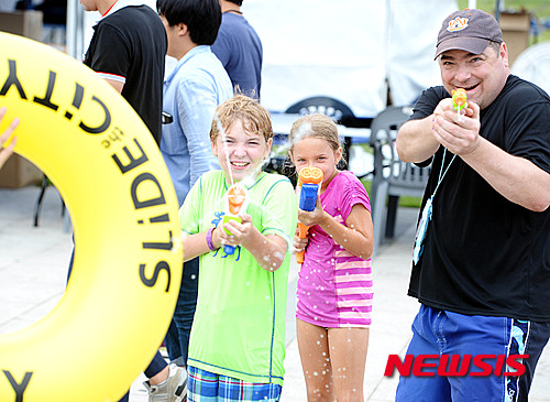 【서울=뉴시스】박문호 기자 = 초대형 워터슬라이드와 신나는 물싸움, 짜릿한 수상레포츠와 다양한 공연을 한 번에 즐길 수 있는 '한강몽땅 여름축제'가 열린 19일 오후 서울 영등포구 여의도동 여의도한강공원을 찾은 외국인 가족이 물총 싸움을 하며 즐거운 시간을 보내고 있다. 2015.07.19.&nbsp;&nbsp; go2@newsis.com 