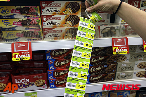 【아테네=AP/뉴시스】그리스 국민들이 세금 인상에 따른 물가 급등으로 고심에 빠졌다. 사진은 20일(현지시간) 아테네의 한 슈퍼마켓에서 종업원이 새로운 부가가치세 가격표로 교체하는 모습. 2015.07.21