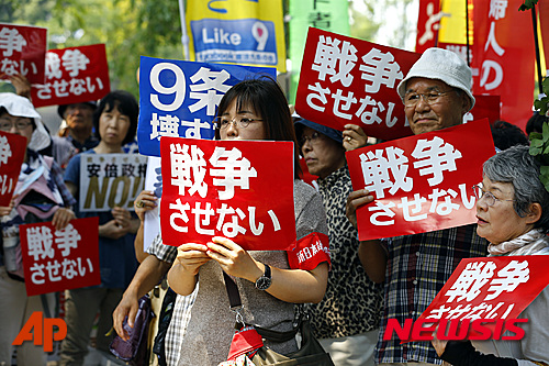 【도쿄=AP/뉴시스】시위대들이 일본 참의원이 안보 관련 법안 심의를 시작한 2015년 7월27일 도쿄 국회 밖에 모여 '전쟁 반대'라고 적힌 플래카드를 들고 시위를 벌이고 있다. 집단적 자위권 행사를 가능하게 한 안전보장법은 이른바 평화헌법으로 불리는 헌법 제9조를 위반한 것으로 평화롭게 살 권리를 침해한다며 후쿠시마(福島)현 주민 등이 정부에 손해배상을 청구한 소송에서 센다이(仙台) 고등법원은 5일 "집단적 자위권 행사가 헌법 제9조에 위반한다고 볼 수 없다"며 소송을 기각했다고 NHK가 보도했다. 2023.12.05.