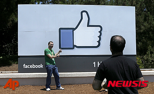 【멘로파크(미 캘리포니아주)=AP/뉴시스】지난 2014년 6월 11일(현지시간) 미국 캘리포니아 멘로파크의 페이스북 캠퍼스에서 한 남성이 페이스북의 ‘좋아요’ 표시 앞에서 사진을 찍고 있다. 전세계 온라인 사용 인구의 약 절반이 페이스북을 사용하는 것으로 드러났다. 2015.07.30