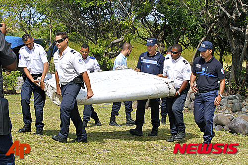 【AP/뉴시스】 지난 달 27일 프랑스 군인들이 인도양의 프랑스령 섬 레위니옹 항구 셍땅드르에서 발견된 비행기 잔해를 운반하고 있다. 말레이시아 당국은 2일 이 파편이 실종된 말레이항공 MH370 편과 같은 보잉 777 기 것으로 확인됐다고 말했다. 2015. 8. 2.