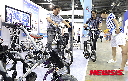 【고양=뉴시스】최진석 기자 = 7일 오전 경기도 고양시 킨텍스에서 열린 2015 월드가전브랜드쇼를 찾은 관람객들이 접이식 전기자전거를 살펴보고 있다. 2015.08.07.&nbsp; myjs@newsis.com
