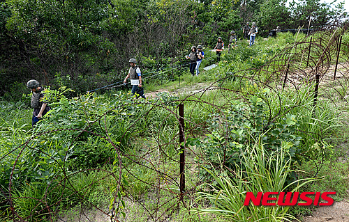【서울=뉴시스】지난 9일 취재진들이 추진철책 옆길을 통해 사고현장으로 이동하고 있다.&nbsp; 지난 4일 경기도 서부전선 비무장지대(DMZ)에서 육군 모부대 소속 장병들이 수색작전을 하던 중 '목함지뢰' 3발에 의해 김모·하모 하사 등 부사관 2명이 크게 다쳐 국군수도병원으로 이송돼 치료를 받았으며 생명에는 지장이 없는 것으로 밝혀졌다. 2015.08.10. (사진=국방부 공동취재진)&nbsp; photo@newsis.com