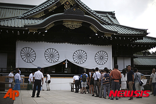 【도쿄=AP/뉴시스】2차 세계대전 주범으로 꼽히는 도조 히데키(東條英機) 전 일본총리의 증손자인 도조 히데토시(東條英壽·가운데)가 지난 13일 야스쿠니 신사에서 참배하고 있다. 야스쿠니 신사에는 태평양전쟁 A급 전범 14명을 포함해 246만6000여명의 위패가 합사돼 있다. 2015.08.16.