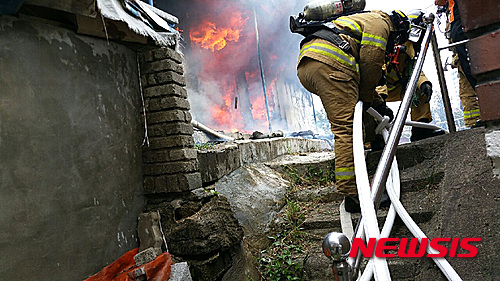 【속초=뉴시스】김경목 기자 = 16일 오후 1시29분께 강원 속초시 동명동 단층 가옥에서 원인이 밝혀지지 않은 불이 난 가운데 강원 속초소방서 소방관들이 화재를 진압하고 있다. 2015.08.16. (사진=속초소방서 제공)&nbsp; photo31@newsis.com