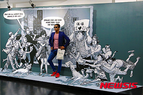 김정기 작가가 그린 그림으로 만든 포토존에서 사진을 찍고 있는 관람객(사진=레스빠스71갤러리)