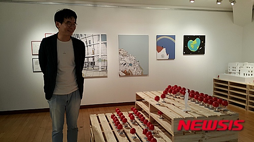 【서울=뉴시스】박현주 기자= 필명 '오기사'로 알려진 건축가 오영욱이 서울 통의동 진화랑에서 4일부터 개인전을 연다. 갤러리에 전시된 빨간 안전모를 쓴 '오기사' 캐릭터 인형을 바라보고 있다.