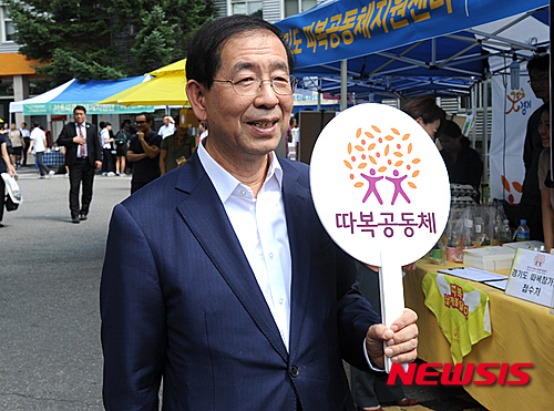 [서울=뉴시스]김선웅 인턴기자 = 고(故) 박원순 전 서울시장이 지난 2015년 9월10일 당시 서울 은평구 서울혁신파크에서 열린 서울마을박람회에 참석해 공동체 이름이 적힌 피켓을 들고 있는 모습. 2015.09.10. (사진=서울시청 제공) photo@newsis.com