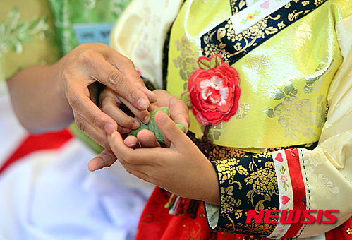 【서울=뉴시스】조성봉 기자 = 16일 오전 서울 송파구 서울놀이마당에서 열린 ‘새마을부녀회가 함께하는 한가위 다문화 어울림 한마당’에서 다문화여성이 딸과 함께 송편을 빚고 있다. 2015.09.16. suncho21@newsis.com