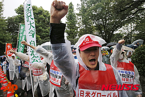 【도쿄=AP/뉴시스】집단적 자위권 행사를 용인하는 안보 관련 법안에 반대하는 시위대가 17일 도쿄의 일본 국회의사당 앞에서 법안에 반대하는 구호를 외치고 있다. 그러나 자민·공명 집권 여당은 이날 야당 의원들의 거센 반대에도 참의원 평화안전법제특별위원회에서 표결을 강행해 법안을 통과시켰다. 2015.9.17