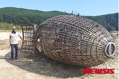 【서울=뉴시스】 박현주 기자= 이종균 작가가 대나무와 전선타이로 만든 '쓰레기 물고기 탐색자'를 설명하고 있다.