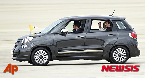 【워싱턴=AP/뉴시스】교황 프란치스코가 22일(현지시간) 미국 워싱턴 인근 메릴랜드주(州) 앤드루스 공군기지에 도착해 숙소 워싱턴의 교황청 대사관저로 이동하면서 탄 피아트 500L에서 사람들에게 손 흔들며 인사하고 있다. 미국을 처음 방문한 교황은 이날 피아트 클라이슬러가 생산한 경차인 피아트 500L를 타고 이동하며 친 서민 행보를 보여줬다. 2015.09.23