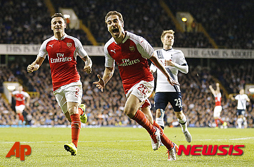 Arsenal's Mathieu Flamini , center, celebrates after scoring during the English League Cup third round soccer match between Tottenham Hotspurs and Arsenal at White Hart Lane stadium in London, Wednesday, Sept. 23, 2015. (AP Photo/Frank Augstein)