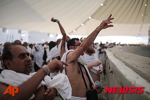 【미나=AP/뉴시스】24일 사우디 아라비아의 성지인 메카 인근 미나에서 이슬람 순례자들이 이른바 '자마라트'로 불리는 종교의식 일환으로 악마를 상징하는 기둥 앞에 돌을 던지고 있다. 2015.09.24