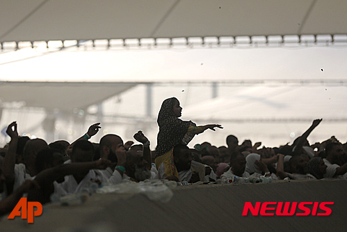 【미나=AP/뉴시스】24일 사우디 아라비아의 성지인 메카 인근 미나에서 이슬람 순례자들이 이른바 '자마라트'로 불리는 종교의식 일환으로 악마를 상징하는 기둥 앞에 돌을 던지고 있다. 2015.09.24