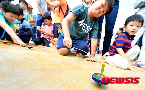 【서울=뉴시스】김동민 기자 = 오(五)대감 한가위잔치가 28일 오후 서울 중구 남산골한옥마을에서 열린 가운데 어린이들이 팽이치기를 하고 있다.&nbsp;&nbsp; 오대감 한가위잔치에는 동전 던지기, 활 만들기, 연 만들기, 팽이 만들기 등 전통체험과 차례상 해설 등 세시체험 등의 프로그램이 진행됐다. 2015.09.28.&nbsp; life@newsis.com