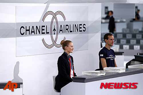 【파리=AP/뉴시스】프랑스 패션브랜드 샤넬 직원들이 6일(현지시간) 파리에서 열린 2016년 봄/여름 시즌 프레타포르테 패션쇼 장 입구에서 마치 비행기 승무원같은 의상을 입고 입장객들을 맞이하고 있다. 2015.10.6