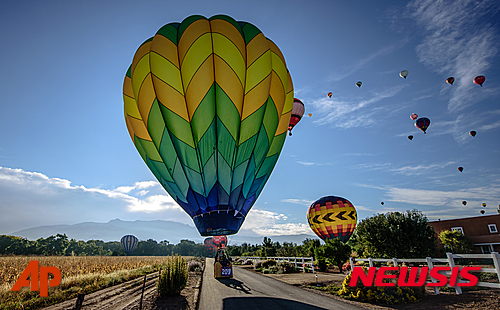 【앨버커키=AP/뉴시스】해마다 10월이면 미 뉴멕시코주 앨버커키에서 열리는 세계열기구축제에서 열기구들이 넓은 들판에 착륙하기 시작하는 모습. 올 45차 앨버커키 열기구대회는 2일 발생한 열기구의 전선충돌 사고로 3일 하루동안 중단됐다. 2016.10.04