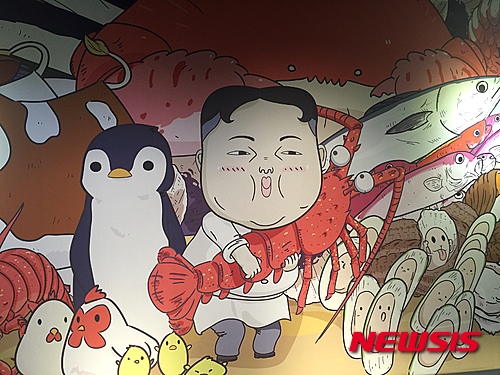 【뉴욕=뉴시스】 중국 광둥성(廣東省)에 북한 김정은 조선노동당 제1비서의 얼굴을 풍자한 식당이 화제를 불러 일으키고 있다고 7일 '글로벌웹진' 뉴스로(www.newsroh.com) 가 전했다. 화제의 식당은 지난 1일 중국의 국경절에 개업을 한 해산물 전문식당 '조선(潮仙)'이다. 북한의 공식 국명인 조선(朝鲜)과는 한자가 다르지만 같은 한글 발음으로 다분히 풍자의 의도를 드러내고 있다. 간판엔 '조선'이라는 옥호와 함께 김정은 제1비서로 추정되는 캐리커처가 있고 한글로 '조선 해물찜'이라는 글씨도 써 있다. 식당에 들어서면 인테리어는 물론, 메뉴판과 주방 출입커튼, 그릇, 컵, 커튼 심지어 젓가락 보까지 비슷한 캐릭터가 그려져 시선을 끈다. <사진=Newsroh.com 제공> 
