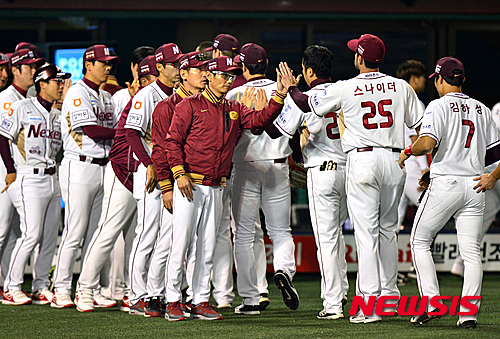 【서울=뉴시스】 배훈식 기자 = 13일 오후 서울 양천구 목동야구장에서 열린 '2015 KBO 리그' 준플레오프 3차전에서 두산 베어스를 꺾으며 기사회생한 넥센 히어로즈 염경엽 감독과 선수들이 하이파이브를 하고 있다. 2015.10.13.&nbsp; dahora83@newsis.com